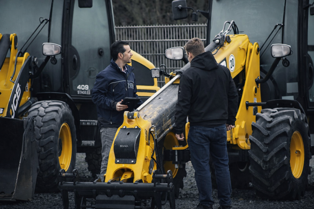Markus Fehr berät einen Kunden an einer Baumaschine